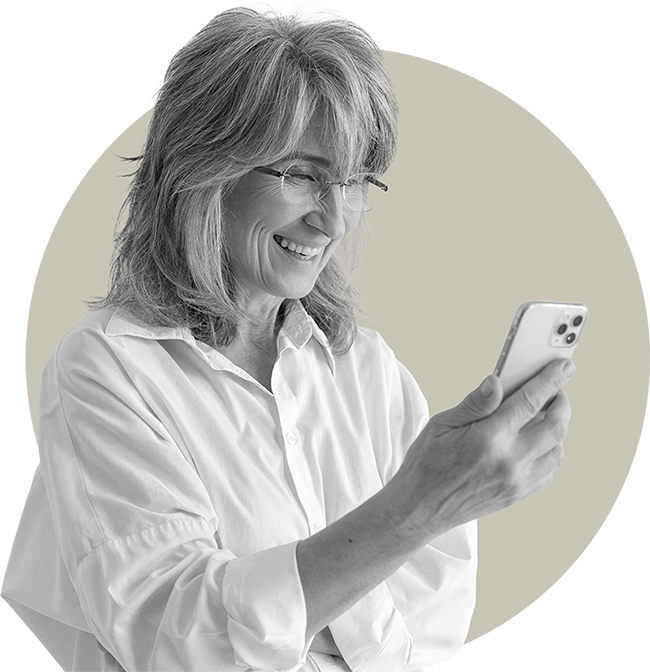 An older woman smiling at her phone